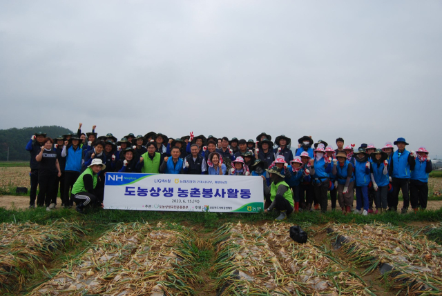 LIG넥스원 구미 생산본부 임직원들이 지난 6월 구미시 해평면에서 농촌일손돕기 봉사활동을 한 후 기념촬영을 하고 있다. LIG넥스원 제공