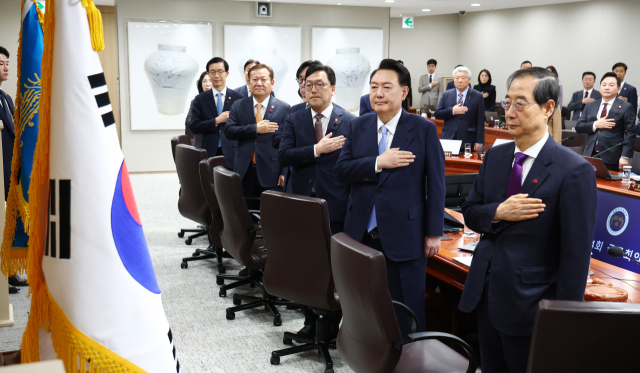 윤석열 대통령, 한덕수 국무총리와 국무위원들이 19일 서울 용산 대통령실 청사에서 열린 국무회의에서 국기에 경례하고 있다. 연합뉴스
