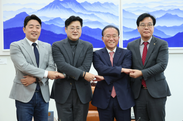 여야 원내대표와 국회 예결위 여야 간사가 7일 국회 운영위원장실에서 열린 여야 예산안 2+2 협의체 회의에서 손을 맞잡고 기념촬영을 하고 있다. 왼쪽부터 더불어민주당 강훈식 의원, 홍익표 원내대표, 국민의힘 윤재옥 원내대표, 송언석 의원. 연합뉴스