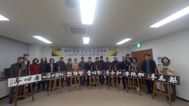 대구 군위군 삼국유사 웅산서각동아리 회원들이 정자 현판을 제작해 읍면장에게 전달하고 있다. 군위군 제공
