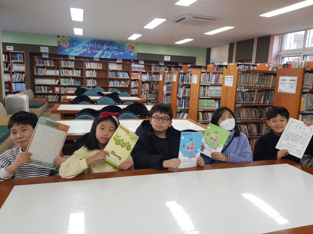 독해 능력을 높이도록 교사들이 개발한 독서기록장을 들고 있는 대구 경동초 학생들. 경동초 제공