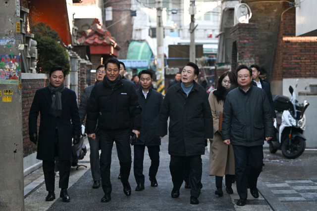 윤석열 대통령이 21일 서울 중랑구의 소규모주택정비 관리지역인 모아타운 사업지를 방문해 원희룡 국토교통부 장관, 오세훈 서울시장, 조규홍 보건복지부 장관 등과 함께 현장을 시찰하고 있다. 연합뉴스