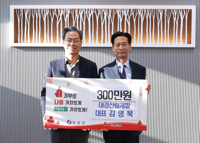 김영묵 대경산림개발 대표(전 농업경제건설국장)이 21일 오도창 영양군수(왼쪽)에게 지역민을 위한 성금을 전달하고 기념 촬영을 하고 있다. 영양군 제공