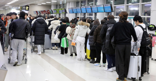 21일 오후 제주공항에 폭설과 강풍이 불면서 항공편이 무더기로 결항한 가운데 이용객들이 항공편 변경을 위해 줄을 서서 기다리고 있다. 연합뉴스