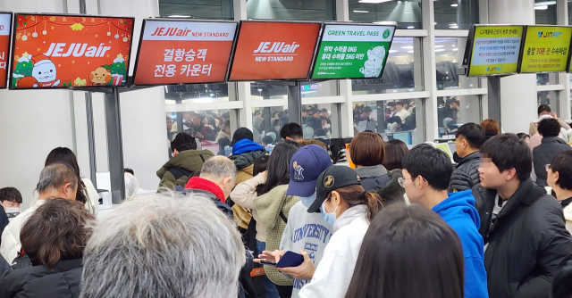 21일 오후 제주공항에 폭설과 강풍이 불면서 항공편이 무더기로 결항한 가운데 이용객들이 항공편 변경을 위해 줄을 서서 기다리고 있다. 연합뉴스