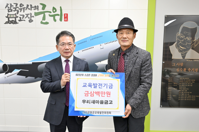 대구 군위군 군위읍 홍유석(오른쪽) 우리새마을금고 이사장이 군위군에 교육발전기금을 기탁하고, 김진열 군수와 기념 사진을 촬영하고 있다. 군위군 제공