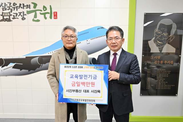 대구 군위군 효령면 서진욱(왼쪽) 서진부동산 대표가 군위군에 교육발전기금을 기탁하고, 김진열 구눗와 기념 사진을 촬영하고 있더. 군위군 제공