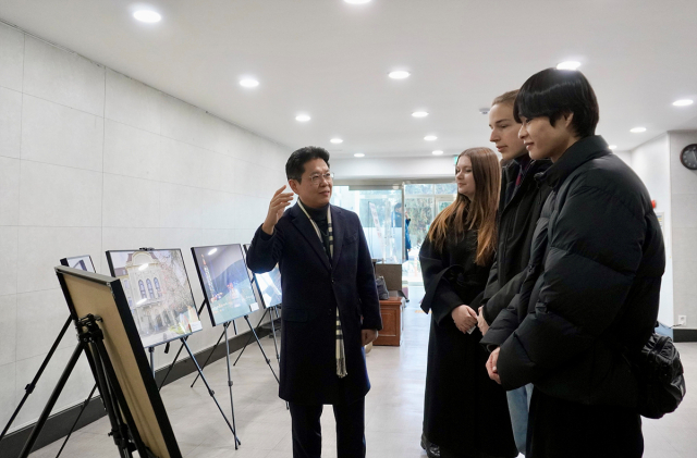 지난 22일 대구시청 산격청사 북카페 앞. 안중곤(왼쪽) 대구시 경제국장과 관람객들이 연말연시 사진전 