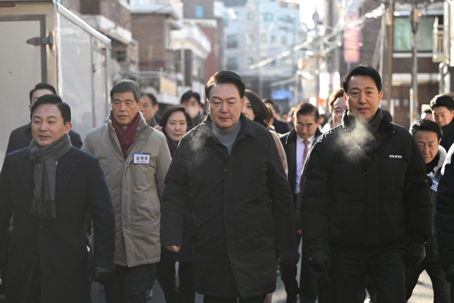 윤석열 대통령이 지난 21일 서울 중랑구의 소규모주택정비 관리지역인 모아타운 사업지를 방문해 원희룡 국토교통부 장관, 오세훈 서울시장 등과 함께 현장을 시찰하고 있다. 연합뉴스