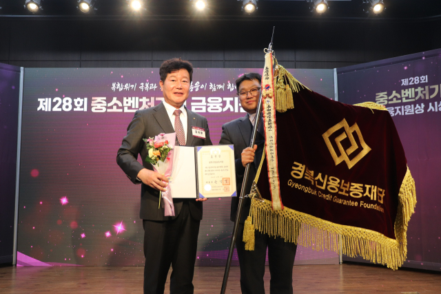 김세환(왼쪽) 경북신보 이사장이 지난 19일 중소벤처기업 금융지원 시상식에서 대통령 기관표창을 수상한 뒤 기념촬영을 하고 있다. 경북신보 제공