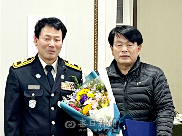 김준길 경산소방서 진량의용소방대원(오른쪽) 퇴임식에서 박주호 진량119 안전센터장이 축하의 꽃다발을 전하고 있다. 경산소방서 제공