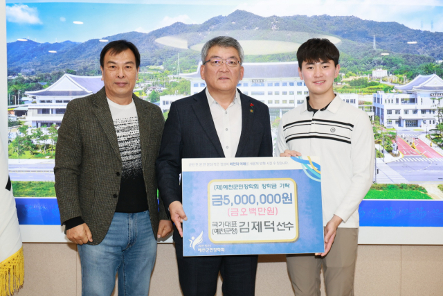 대한민국 양궁 국가대표 김제덕(사진 오른쪽) 선수가 26일 예천군청을 방문해 장학금 500만 원을 기탁하고 기념 촬영을 하고 있다. 예천군 제공