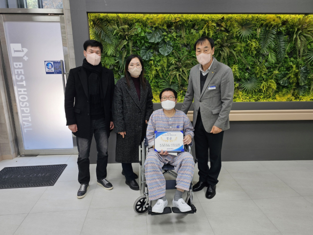 지난 26일 김재천(오른쪽) 금오공고 교장과 교직원들이 행정사무원 A씨에게 치료지원금을 전달한 뒤 사진을 찍고 있다. 금오공고 제공