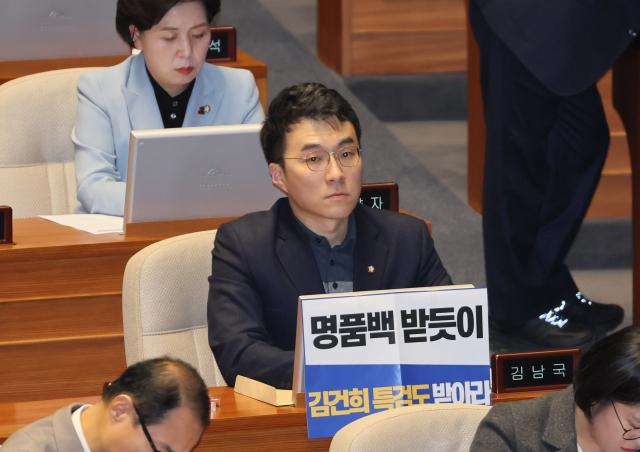 무소속 김남국 의원이 28일 오후 국회 본회의에서 김건희 여사 특검법 수용을 촉구하는 손팻말을 붙이고 있다. 연합뉴스