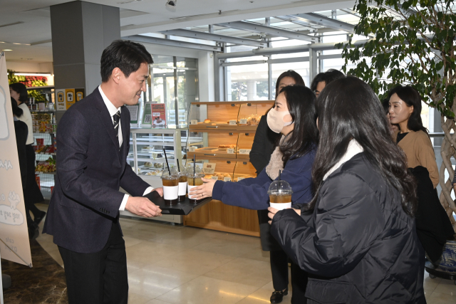최재훈(왼쪽) 달성군수가 29일 오전 출근하는 직원들에게 1층 커피숍에서 구매한 커피를 나눠주고 있다. 이날 최 군수는 모두 601잔의 커피를 직원들에게 제공했다. 달성군 제공.