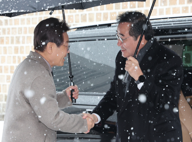 더불어민주당 이재명 대표와 이낙연 전 대표가 30일 오전 서울 중구의 한 식당 앞에서 만나 악수를 하고 있다. 연합뉴스