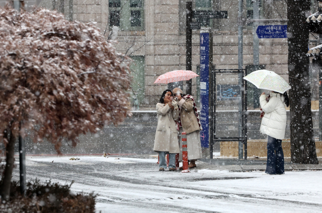 대설주의보가 내려진 30일 오전 서울 중구 덕수궁 인근에서 관광객들이 사진을 찍고 있다. 연합뉴스