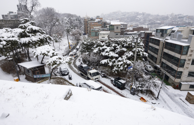 대설주의보가 발효된 30일 오후 서울 종로구 낙산성곽길 인근에서 사고난 차량이 견인되고 있다. 기사 이해를 돕기 위한 자료사진. 연합뉴스