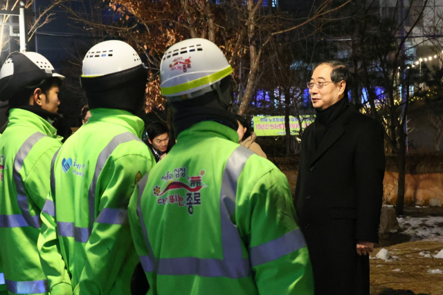 한덕수 국무총리가 1일 새벽 서울 종로구 청진 공원에서 갑진년 첫날 근무에 나선 환경공무원들을 만나 격려하고 있다. 국무총리실 제공.