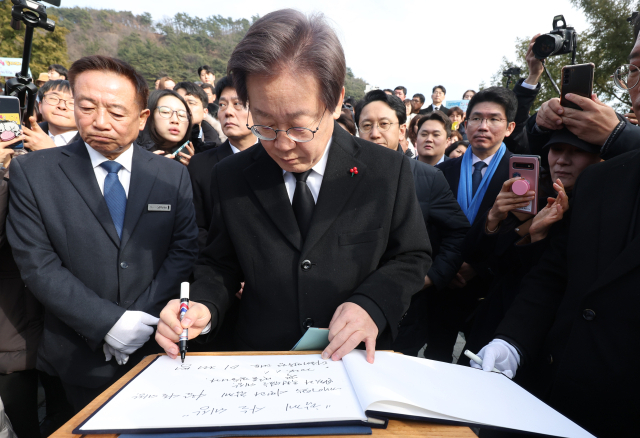 이재명 더불어민주당 대표와 당 지도부가 새해 첫날인 1일 오후 경남 김해시 진영읍 봉하마을 고(故) 노무현 전 대통령 묘역 참배 후 방명록을 남기고 있다. 연합뉴스