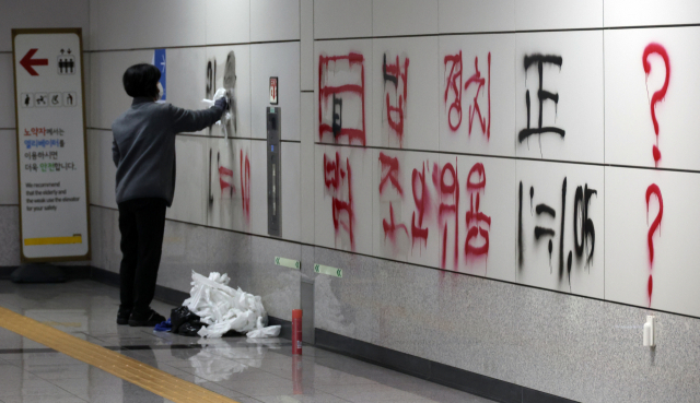 2일 서울 지하철 9호선 국회의사당역에서 직원이 낙서를 지우고 있다. 연합뉴스