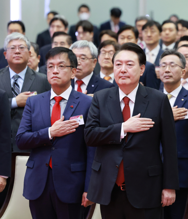 윤석열 대통령이 2일 오전 서울 영등포구 여의도 한국거래소에서 열린 2024 증권·파생상품시장 개장식에서 국기에 대한 경례를 하고 있다. 윤 대통령 왼쪽은 최상목 경제부총리 겸 기획재정부 장관. 연합뉴스