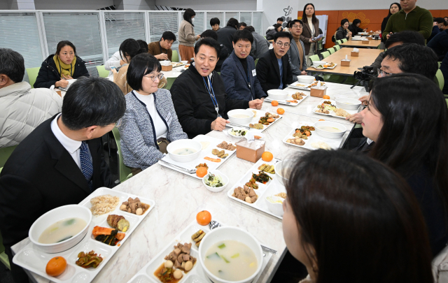 오세훈 서울시장이 2일 오후 서울시청 구내식당에서 열린 신년맞이 직원 격려 떡국 배식행사에서 우수창의제안 수상 공무원들과 함께 식사를 하고 있다. 연합뉴스