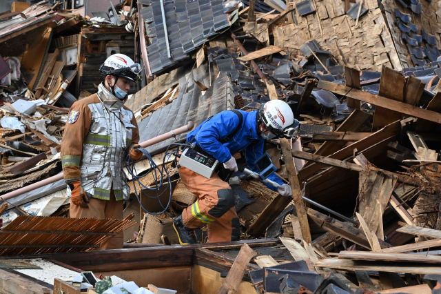 4일 일본 이시카와현 와지마시 주택가에서 구조대원들이 전자감응 장비를 이용해 실종자 수색 작업을 벌이고 있다. 새해 벽두 노토반도를 강타한 지진으로 최소 78명이 사망하고 50여 명이 실종된 것으로 집계됐다. 연합뉴스