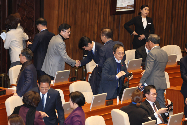 더불어민주당 홍익표 원내대표가 28일 오후 국회 본회의에서 쌍특검법 통과 뒤 퇴장하는 의원들과 악수하고 있다. 연합뉴스