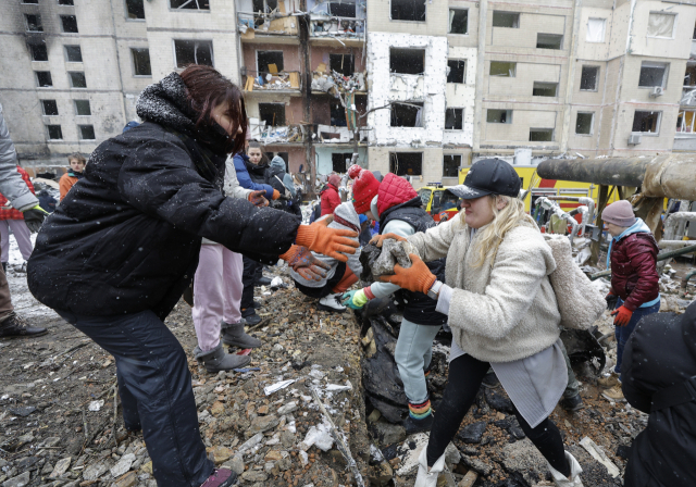 우크라이나 자원봉사자들이 3일(현지시간) 러시아군 공습으로 파손된 건물의 잔해를 치우고 있다. 러시아는 전날 키이우와 동남부 하르키우 등지에 미사일 99대를 퍼부었고, 우크라이나도 러시아 벨고로드 지역에 보복 공격을 단행했다. 연합뉴스