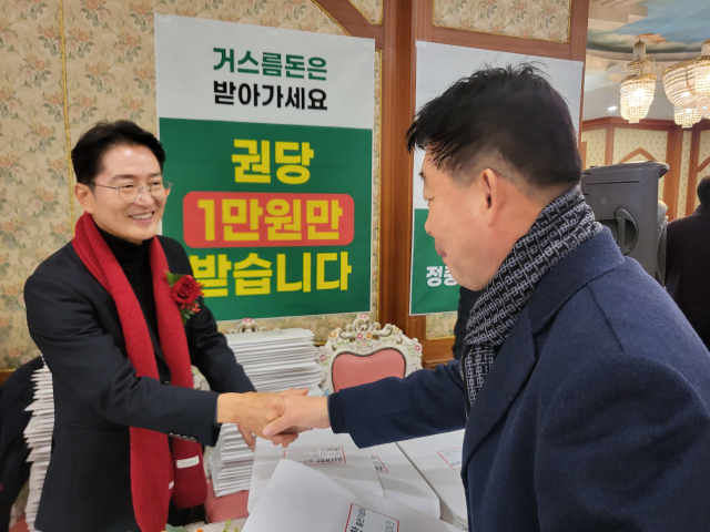 김태한(왼쪽) 예비후보가 출판기념회를 찾은 한 주민과 악수를 하고 있다. 이현주 기자