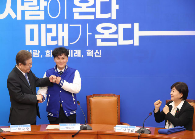 18일 국회에서 열린 더불어민주당 인재영입식에서 이재명 대표가 세 번째 영입 인재인 류삼영 전 총경에게 당 점퍼를 입혀주고 사진촬영을 하고 있다. 연합뉴스