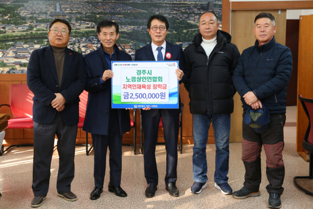 경주시 노점상인연합회 관계자들이 지난 5일 경주시장학회에 장학금을 기탁한 뒤 김성학(가운데) 경주시 부시장과 기념촬영을 하고 있다. 경주시 제공