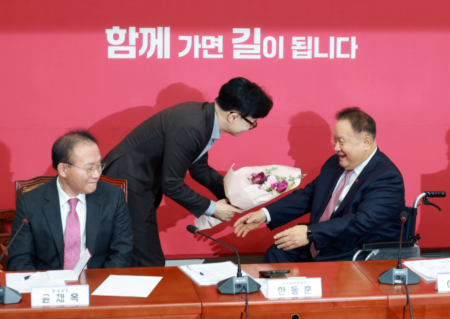 국민의힘 한동훈 비상대책위원장이 8일 국회에서 열린 비상대책위위원회 회의에서 국민의힘에 새로 입당한 이상민 의원에게 환영 꽃다발을 전달하고 있다. 연합뉴스