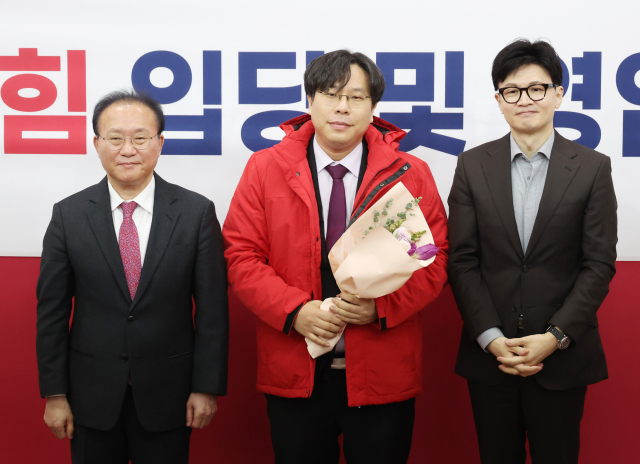 8일 국회에서 열린 국민의힘 입당 및 영입 환영식에서 한동훈 비상대책위원장과 윤재옥 원내대표가 학교폭력 전문 변호사인 박상수 변호사에게 당 점퍼를 입혀주고 기념촬영을 하고 있다. 연합뉴스
