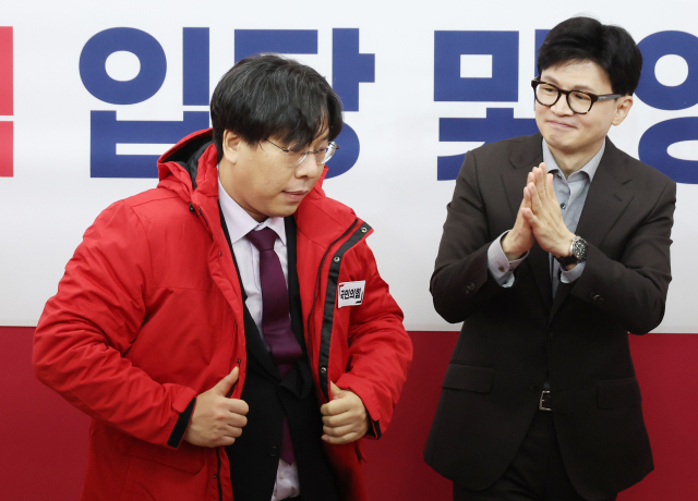 8일 국회에서 열린 국민의힘 입당 및 영입 환영식에서 한동훈 비상대책위원장이 학교폭력 전문 변호사인 박상수 변호사에게 당 점퍼를 입혀주고 있다. 연합뉴스