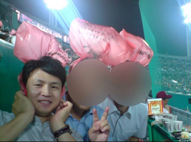 국민의힘이 12일 공개한 한동훈 비상대책위원장의 10여년 전 과거 사진. 부산 사직구장에서 머리에 비닐을 쓰고 응원전을 하고 있다. 국민의힘 공보실