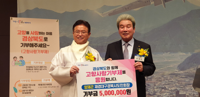 지난해 1월 이철우 경북도지사(사진 왼쪽)에게 고향사랑 기부를 하고 있는 양재곤 회장. 올해도 500만원을 전달할 예정이다. 재경시도민회 제공