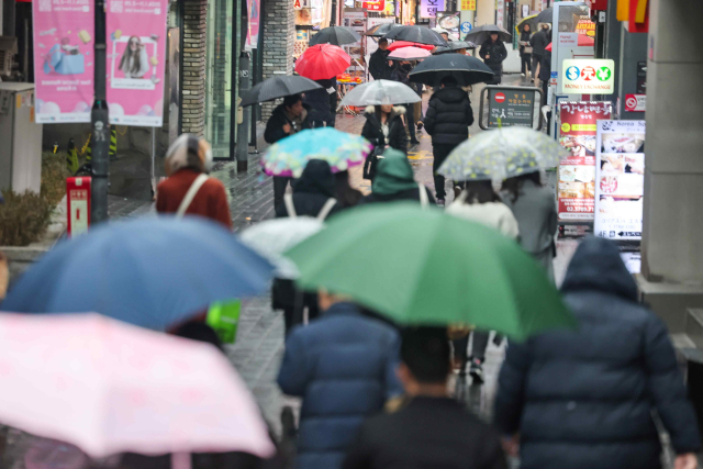 비가 내린 14일 오후 서울 중구 명동거리에서 시민들이 우산을 쓰고 이동하고 있다. 연합뉴스