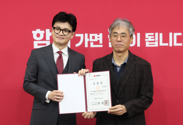 국민의힘 한동훈 비상대책위원장이 29일 국회에서 열린 비상대책위원 임명장 수여식에서 김경률 비대위원에게 임명장을 수여한 뒤 포즈를 취하고 있다. 연합뉴스