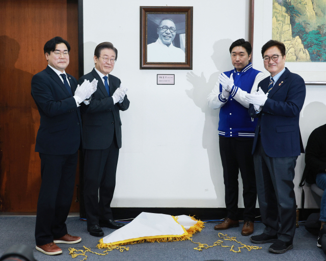 더불어민주당 이재명 대표가 17일 오전 국회에서 열린 인재환영식에서 대한민국임시정부기념사업회 김용만 이사와 함께 김구 선생 사진 제막식을 하고 있다. 이날 인재로 영입된 김 이사는 백범 김구 선생의 증손자이다. 연합뉴스