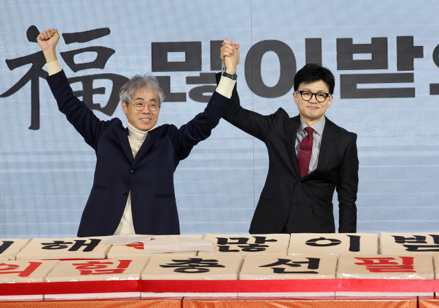 국민의힘 한동훈 비상대책위원장이 17일 오전 서울 마포구 케이터틀에서 열린 서울시당 신년인사회에서 김경율 비상대책위원과 손을 들어 올리고 있다. 연합뉴스
