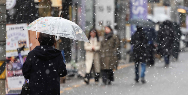 눈이 내린 17일 서울 강남구 강남역 인근에서 시민들이 우산을 쓰고 걷고 있다. 연합뉴스