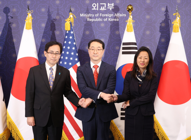 김건 외교부 한반도평화교섭본부장(가운데)과 정박 미국 국무부 대북고위관리(오른쪽), 나마즈 히로유키 일본 외무성 아시아대양주국장이 18일 서울 종로구 외교부 청사에서 열린 한미일 북핵수석대표협의에 앞서 손을 맞잡고 있다. 연합뉴스