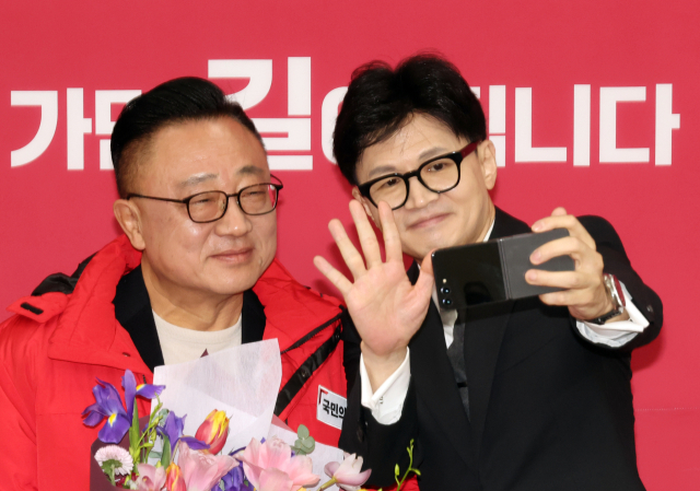 국민의힘 한동훈 비상대책위원장이 22일 국회에서 열린 인재영입 환영식에서 고동진 전 삼성전자 사장과 셀카를 촬영하고 있다. 한 위원장은 아이폰 대신 준비한 갤럭시를 꺼내 촬영했다. 연합뉴스