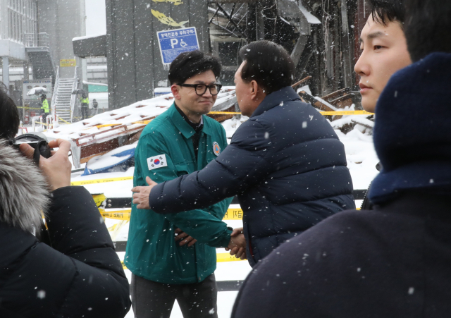 윤석열 대통령이 23일 충남 서천군 서천읍 서천특화시장 화재 현장에서 국민의힘 한동훈 비상대책위원장과 만나 포옹하고 있다. 연합뉴스