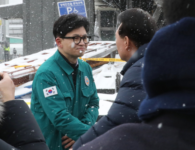 윤석열 대통령과 국민의힘 한동훈 비상대책위원장이 23일 충남 서천군 서천읍 서천특화시장 화재 현장에서 만나 인사하고 있다. 연합뉴스