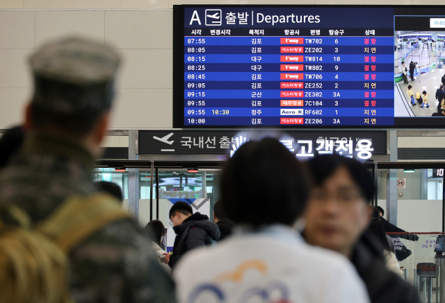 제주에 매서운 눈보라가 친 23일 오전 제주국제공항 국내선 출발층에서 탑승객들이 지연되거나 결항된 항공편 운항 재개를 기다리고 있다. 연합뉴스
