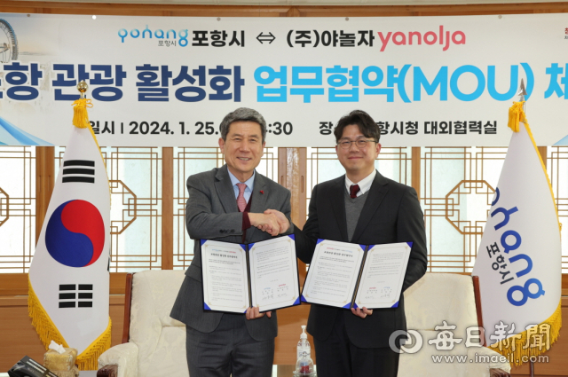 이강덕 포항시장(왼쪽)과 박성식 야놀자 플랫폼 부대표(오른쪽)가 25일 포항지역 관광 활성화를 위한 업무 협약서에 사인한 뒤 악수를 나누고 있다. 포항시 제공