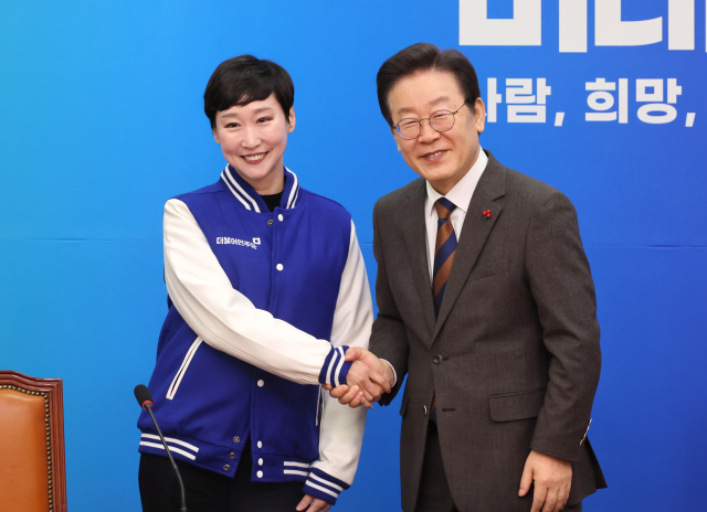 더불어민주당 이재명 대표가 29일 국회에서 열린 11·12차 인재영입식에서 이지은 전 총경에게 당 점퍼를 입혀준 뒤 악수하고 있다. 연합뉴스